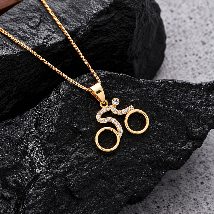 Velorosa bicycle pendant necklace displayed against dark stone